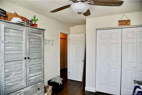a view of a hallway to closet with wooden floor