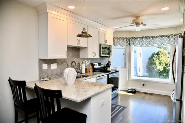 a kitchen with a table chairs and white cabinets