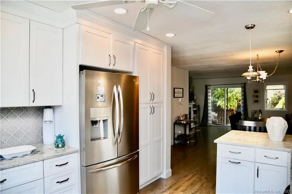 a kitchen with a refrigerator a sink cabinets and wooden floor