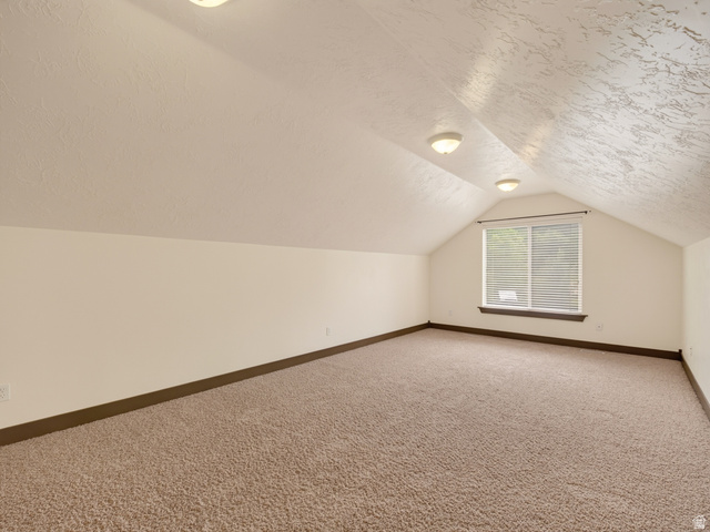 1279 West 1500th Street North Mapleton, UT 84664 - Photo 50 of 83 Carpeted attic space featuring a window with blinds, sloped ceilings, recessed lighting, and white baseboards