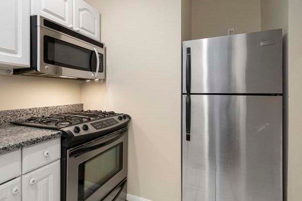 a white refrigerator freezer and a stove sitting inside of a kitchen
