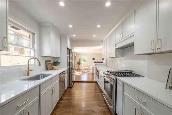 a kitchen with stainless steel appliances a sink stove and cabinets