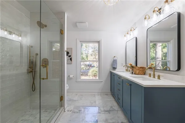 a bathroom with a double vanity sink mirror and shower