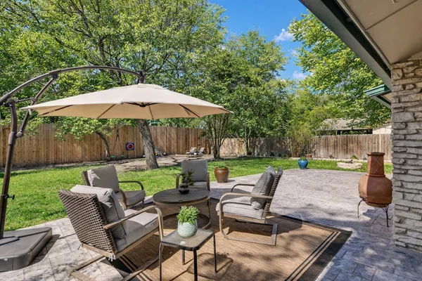 a view of backyard with seating space and trees