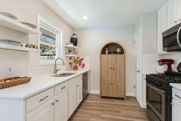 a kitchen with stainless steel appliances granite countertop a sink stove and cabinets