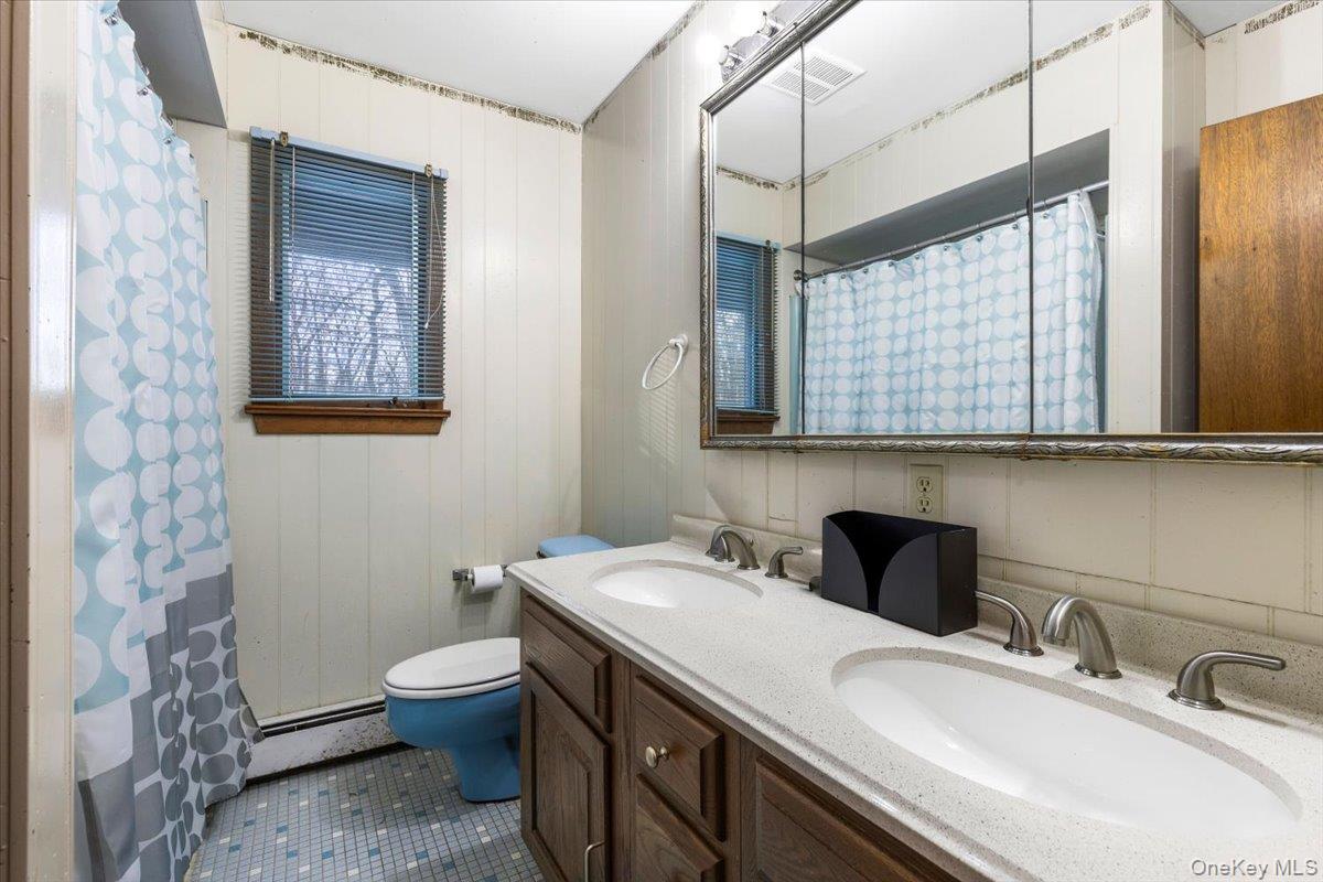 111 Philipse Brook Road Garrison, NY 10524 - Photo 12 of 22 a bathroom with a double vanity sink toilet and mirror