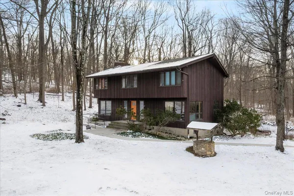 a view of a house with a yard covered in snow