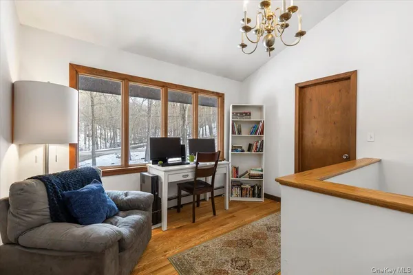 a living room with furniture a desk and a flat screen tv