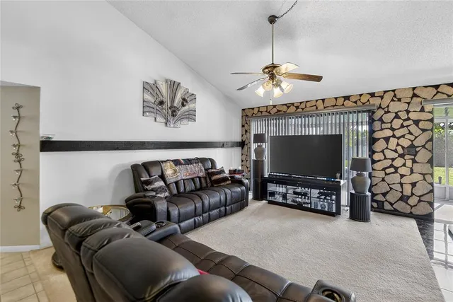 a living room with furniture a flat screen tv and a chandelier