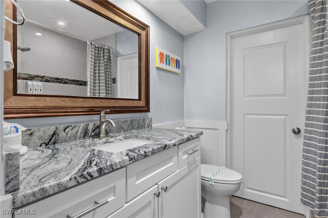 5216 Rutland Court Cape Coral, FL 33904 - Photo 14 of 47 a bathroom with a granite countertop sink a toilet and a mirror