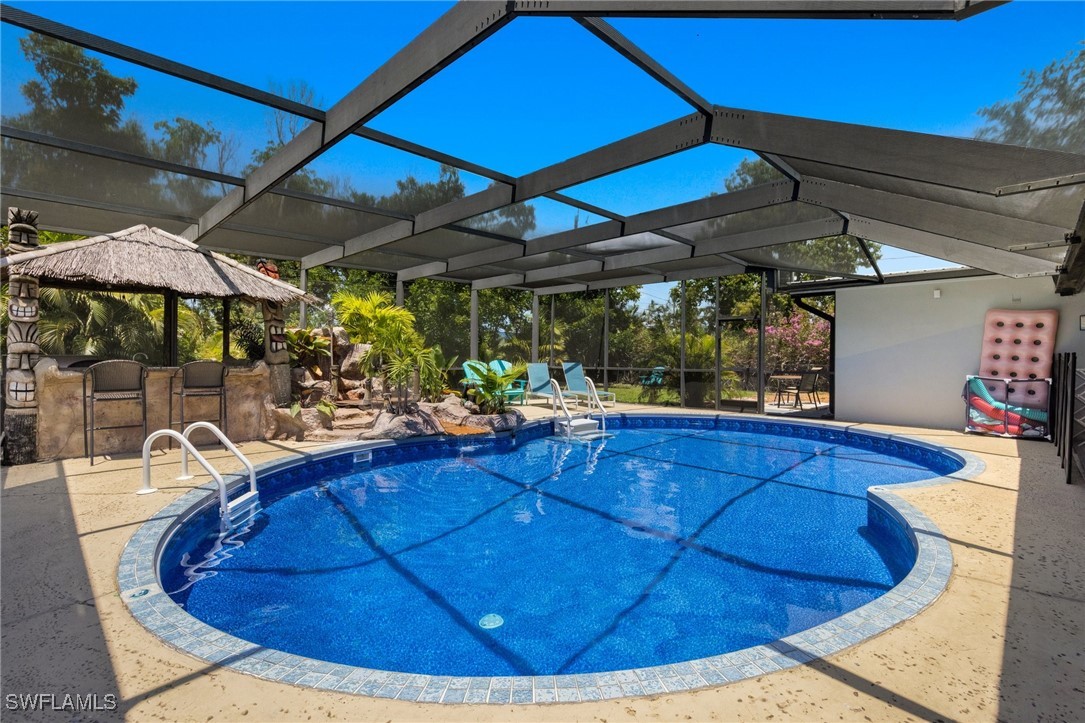 5216 Rutland Court Cape Coral, FL 33904 - Photo 35 of 47 a view of a patio with table and chairs under an umbrella