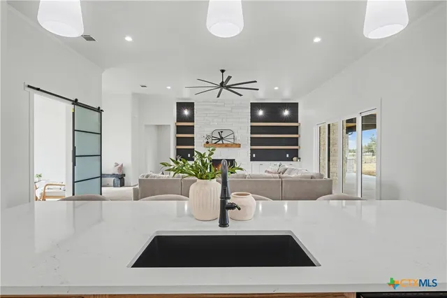 a kitchen with stainless steel appliances a sink a counter top space cabinets and a window