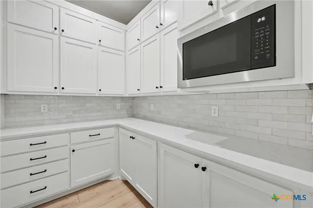 a kitchen with white cabinets stainless steel appliances and sink