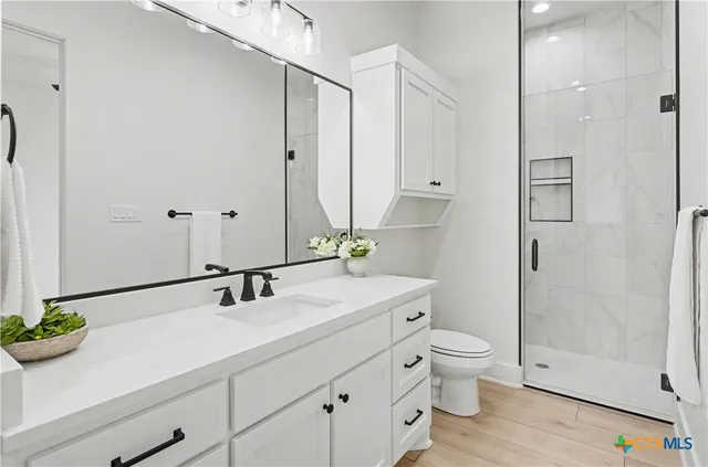 a bathroom with a sink a toilet and shower