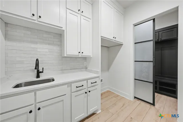 a spacious bathroom with a double vanity sink a mirror and a bathtub