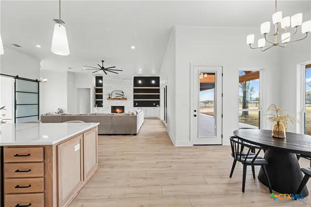a kitchen with stainless steel appliances granite countertop a sink dishwasher and a refrigerator with wooden floor