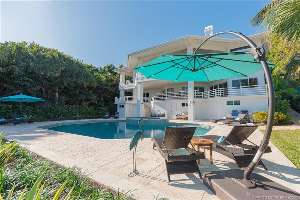 3365 Southeast St Lucie Boulevard Stuart, FL 34997 - Photo 45 of 94 a patio with a table and chairs under an umbrella