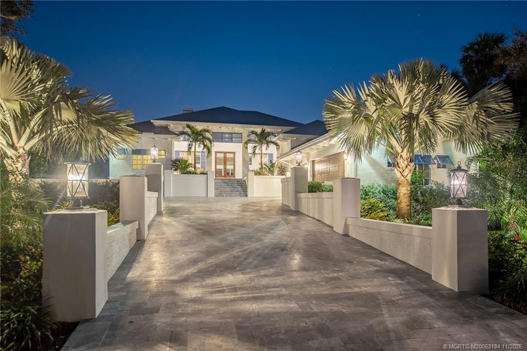 3365 Southeast St Lucie Boulevard Stuart, FL 34997 - Photo 5 of 94 a view of a patio with a table and chairs under an umbrella with palm trees