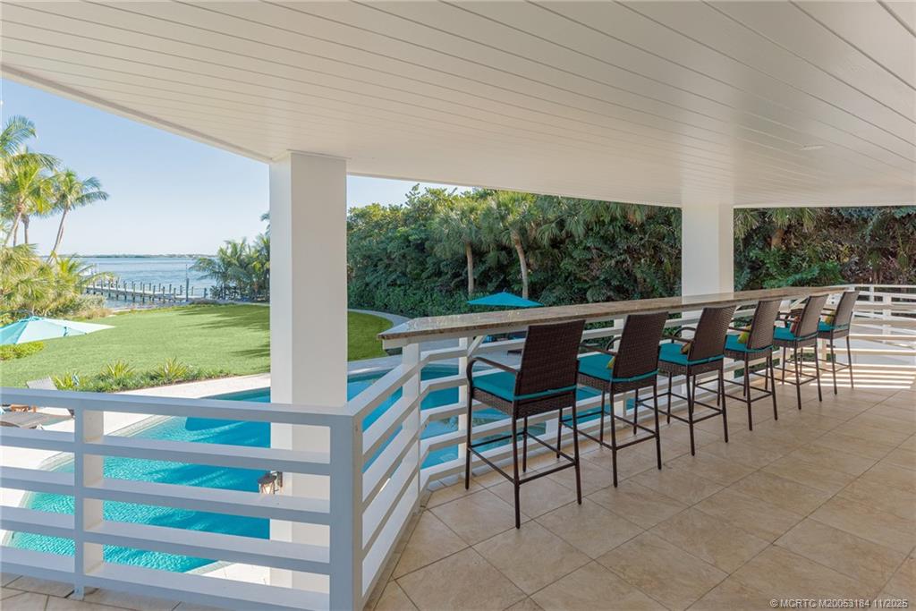 3365 Southeast St Lucie Boulevard Stuart, FL 34997 - Photo 54 of 94 a view of a patio with table and chairs potted plants with floor to ceiling window yard