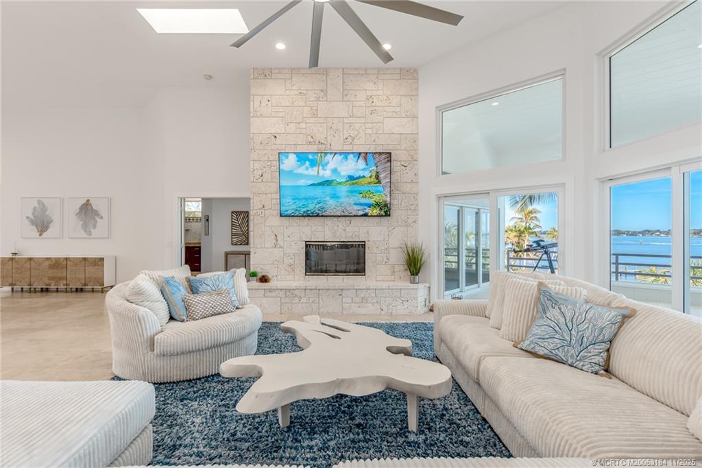3365 Southeast St Lucie Boulevard Stuart, FL 34997 - Photo 65 of 94 a living room with furniture a fireplace and a flat screen tv
