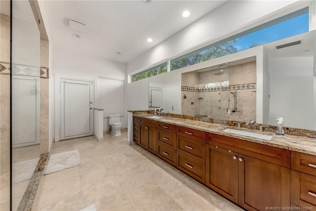 3365 Southeast St Lucie Boulevard Stuart, FL 34997 - Photo 73 of 94 a spacious bathroom with a double vanity sink and a mirror