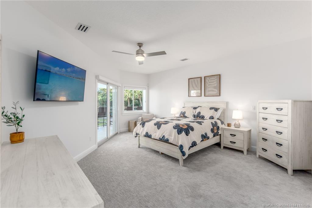 3365 Southeast St Lucie Boulevard Stuart, FL 34997 - Photo 89 of 94 a spacious bedroom with a bed and a flat screen tv