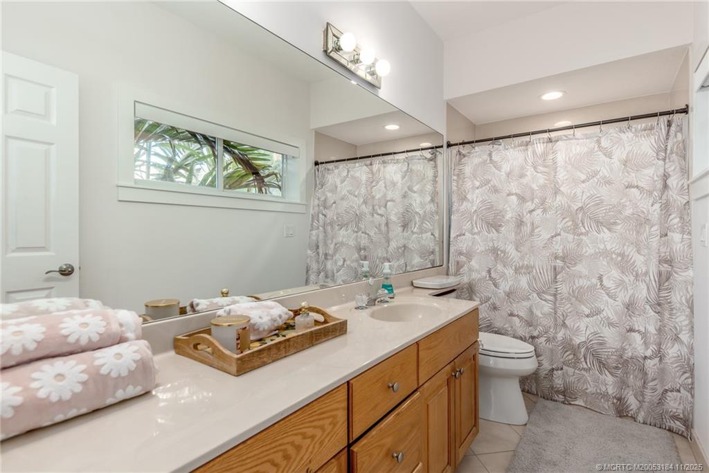 3365 Southeast St Lucie Boulevard Stuart, FL 34997 - Photo 94 of 94 a bathroom with a granite countertop sink a toilet and a shower