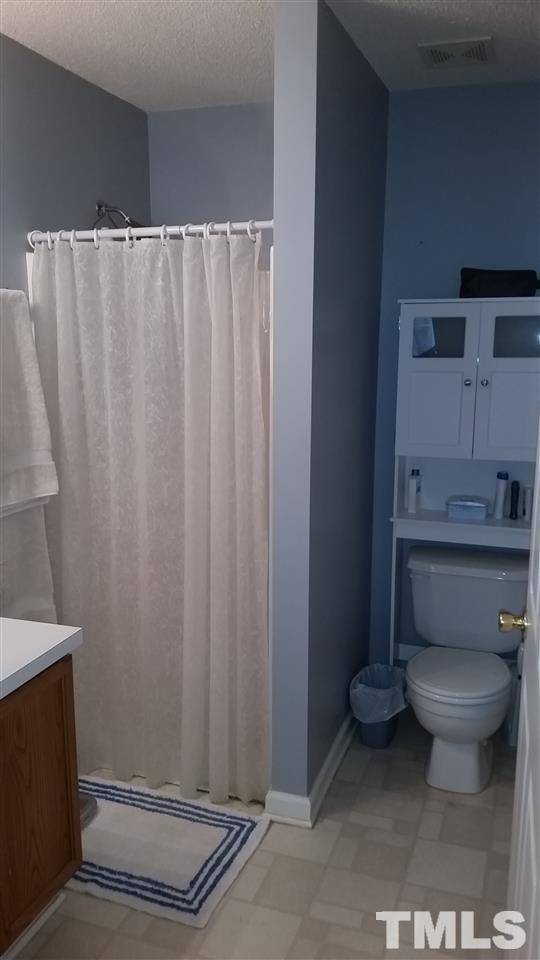 5029 Gable Ridge Drive Durham, NC 27713 - Photo 9 of 11 a bathroom with a toilet and a shower curtain