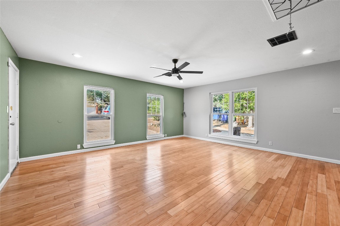 5304 China Berry Road Austin, TX 78744 - Photo 13 of 24 a view of an empty room with a window and wooden floor