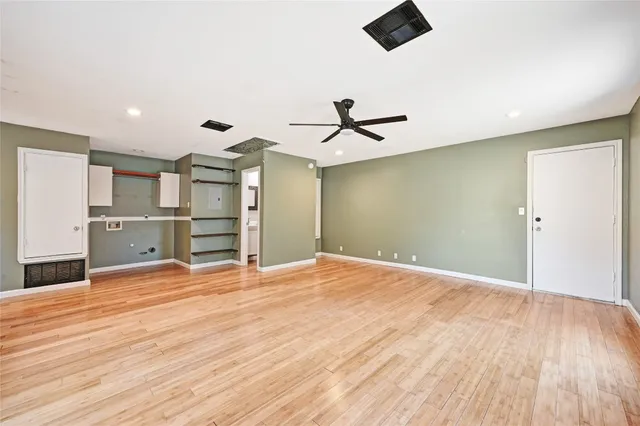 a view of a kitchen with wooden floor and a ceiling fan
