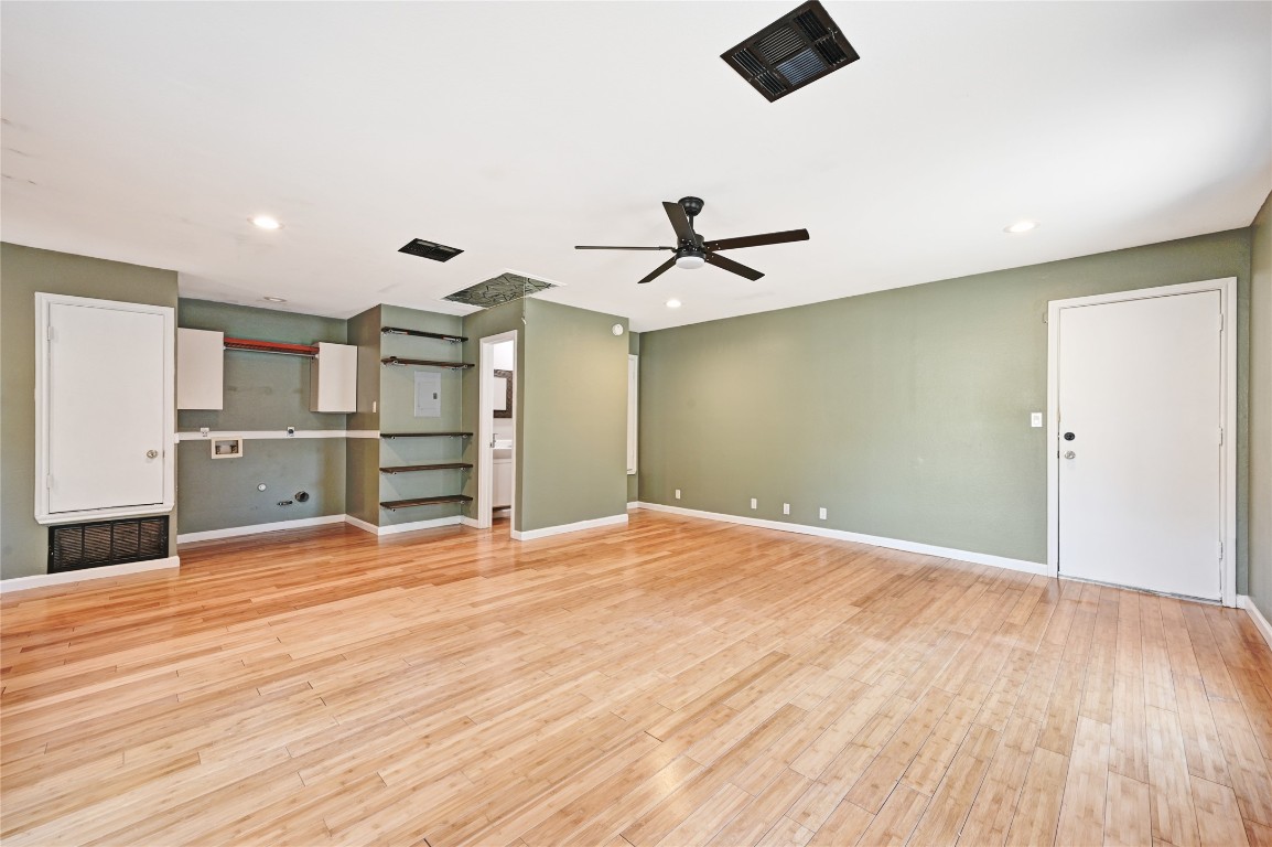 5304 China Berry Road Austin, TX 78744 - Photo 14 of 24 a view of a kitchen with wooden floor and a ceiling fan