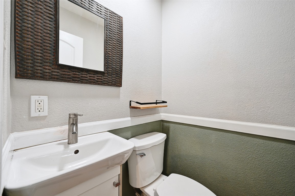 5304 China Berry Road Austin, TX 78744 - Photo 15 of 24 a bathroom with a sink mirror and toilet