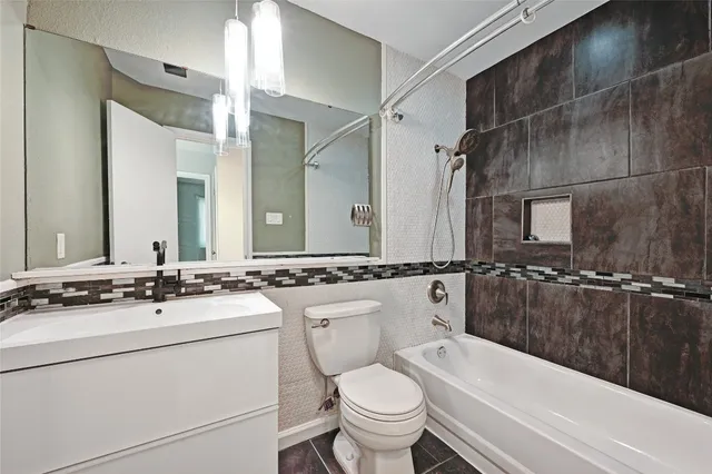 a bathroom with a sink a toilet a mirror a bathtub and shower