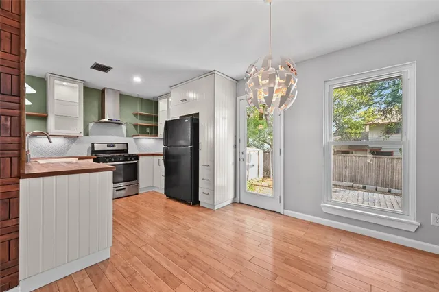a kitchen with stainless steel appliances granite countertop a refrigerator and a stove top oven