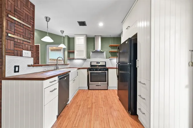 a kitchen with stainless steel appliances a refrigerator sink and stove