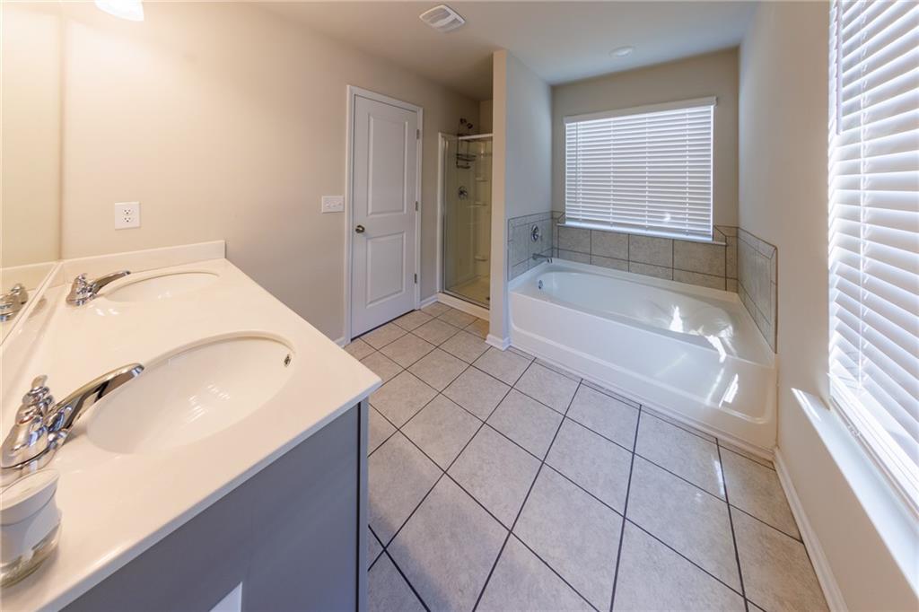 3375 Highbury Way Lithonia, GA 30038 - Photo 12 of 21 a bathroom with a granite countertop sink a mirror and a bathtub