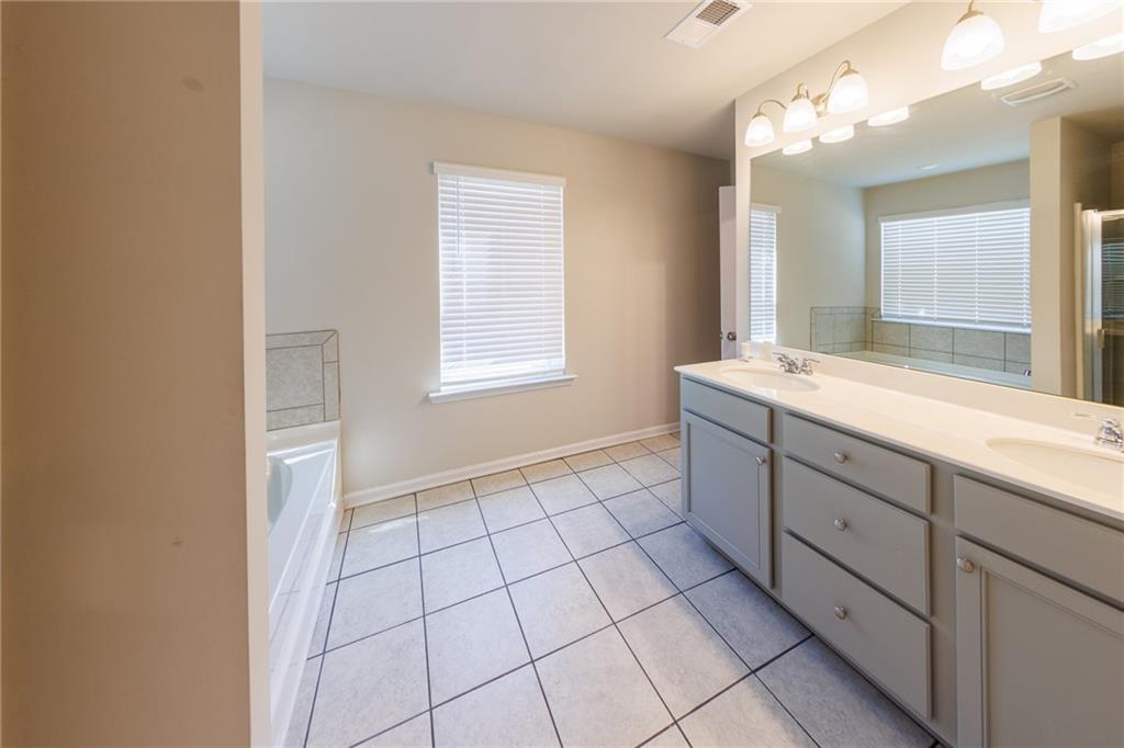 3375 Highbury Way Lithonia, GA 30038 - Photo 13 of 21 a spacious bathroom with a shower a sink and a mirror