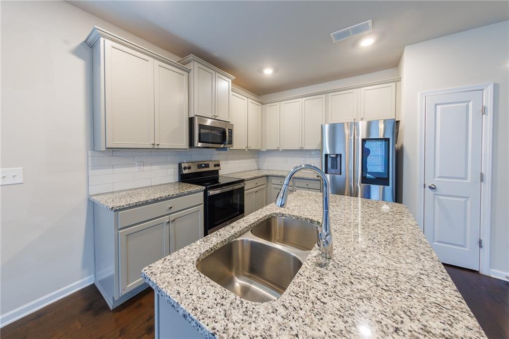 3375 Highbury Way Lithonia, GA 30038 - Photo 6 of 21 a kitchen with stainless steel appliances granite countertop a sink refrigerator and microwave