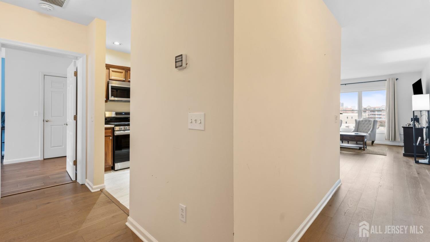 344 The Promenade Edgewater, NJ 07020 - Photo 13 of 44 a view of a hallway with wooden floor and a living room
