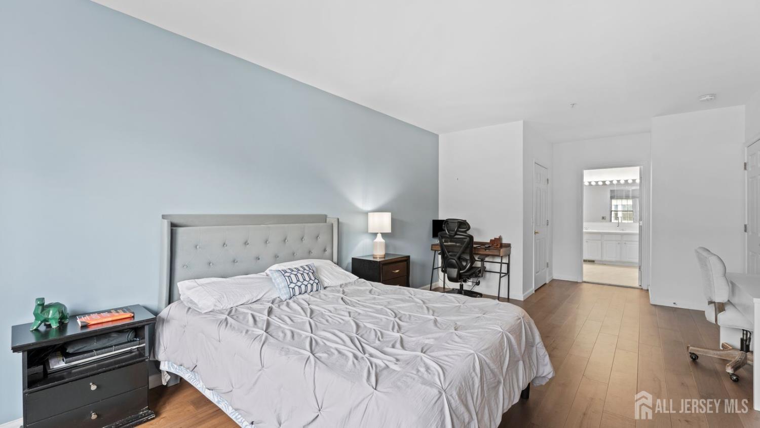 344 The Promenade Edgewater, NJ 07020 - Photo 21 of 44 a bedroom with a bed and a dresser with wooden floor