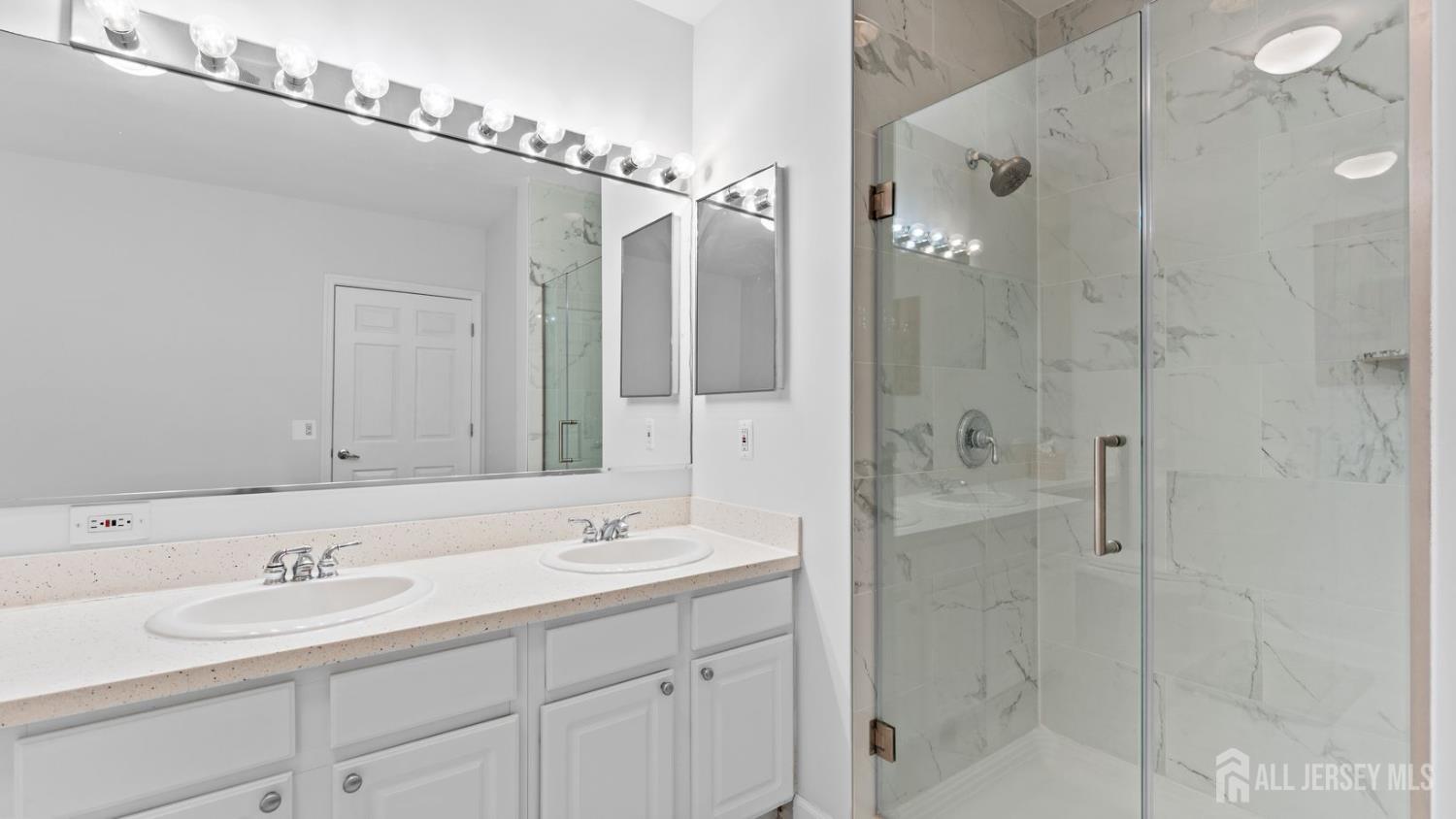 344 The Promenade Edgewater, NJ 07020 - Photo 29 of 44 a bathroom with a shower sink and mirror