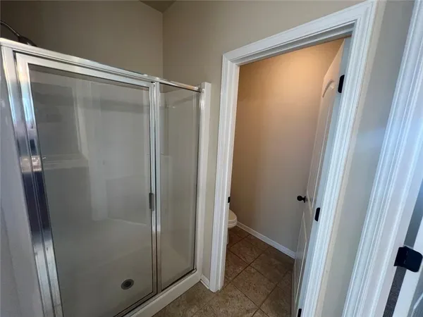 a bathroom with a glass shower door