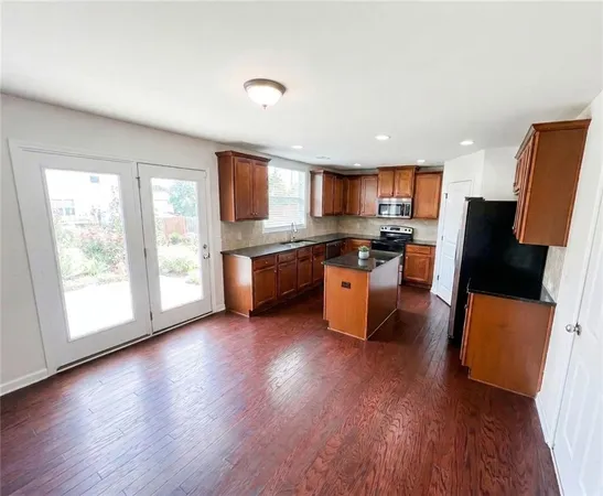 a kitchen with stainless steel appliances granite countertop wooden floors and view living room