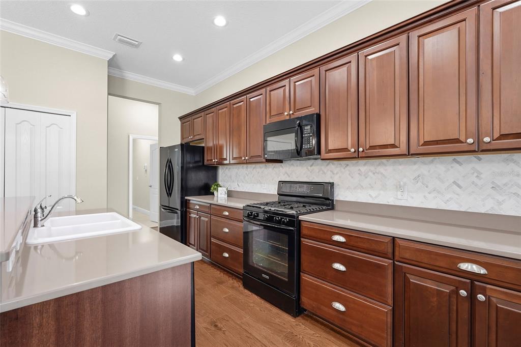 357 Marsh Creek Road Venice, FL 34292 - Photo 12 of 70 a kitchen with kitchen island granite countertop wooden cabinets and a stove top oven