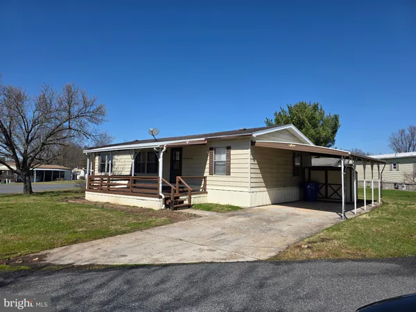 a front view of house with yard and trees in the background