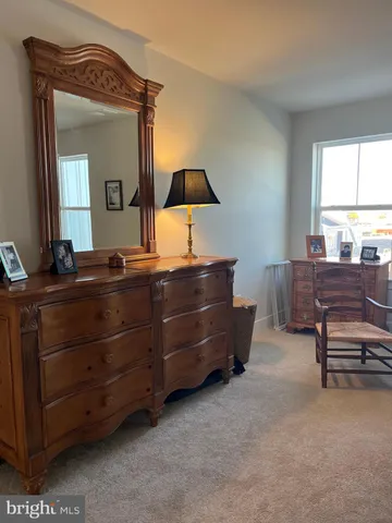 a room with a bed dresser and a window