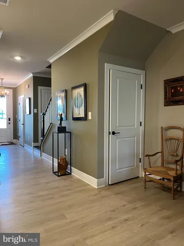 a view of a livingroom with stairs and a workspace