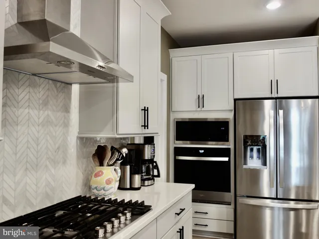 a kitchen with a refrigerator and a stove top oven