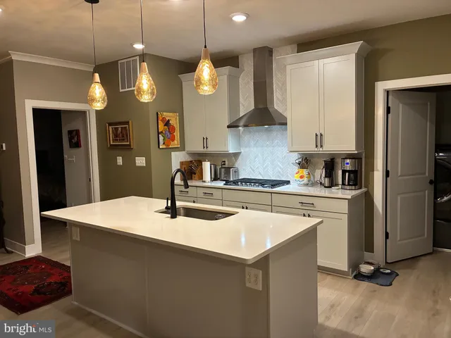 a kitchen with a sink a refrigerator and a stove top oven