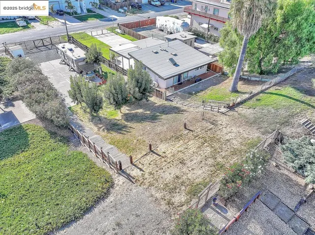 a living room with stainless steel appliances furniture a rug and a kitchen view